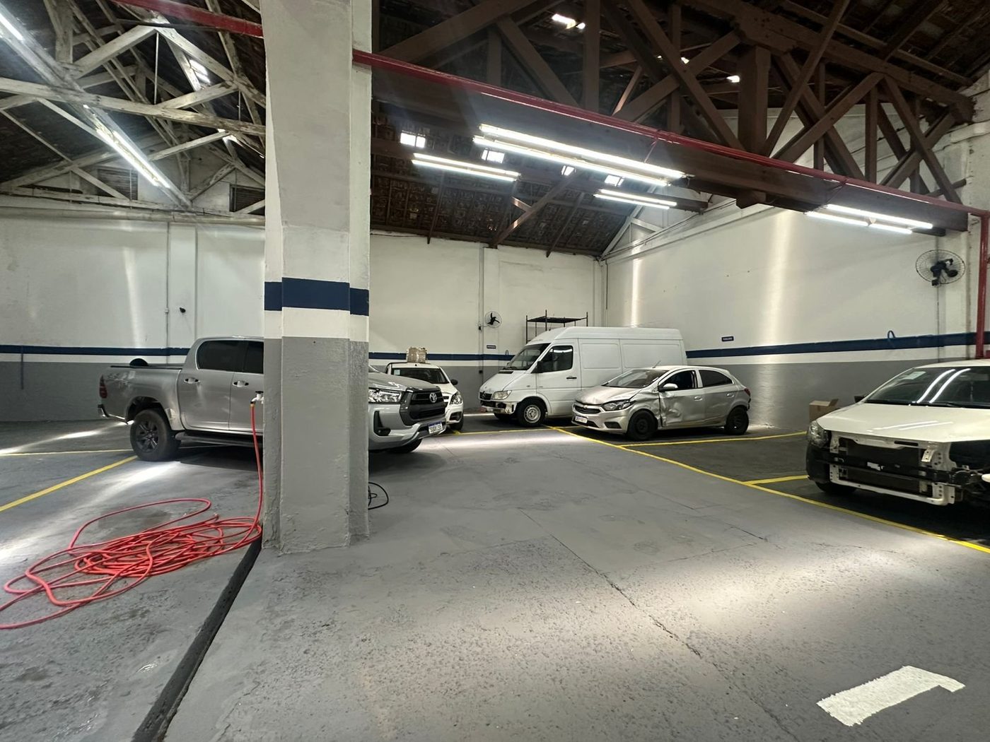 Pátio interno da oficina com veículos aguardando reparo